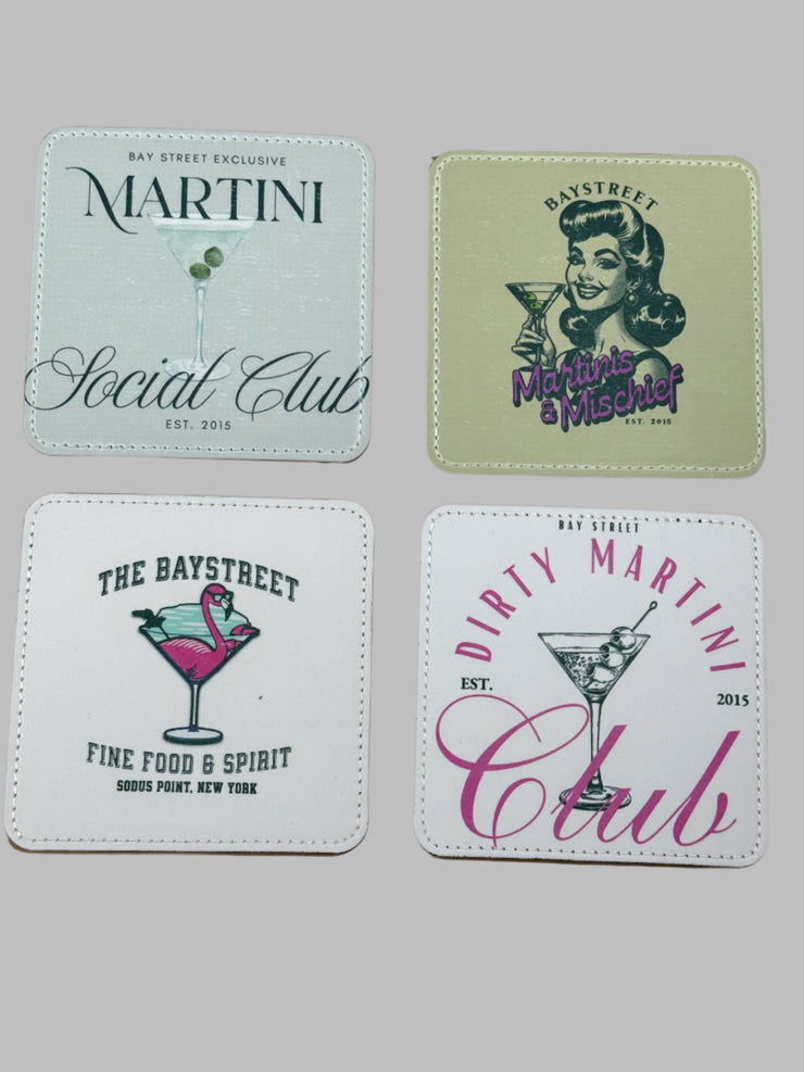 Four coasters with different designs on a hardboard surface