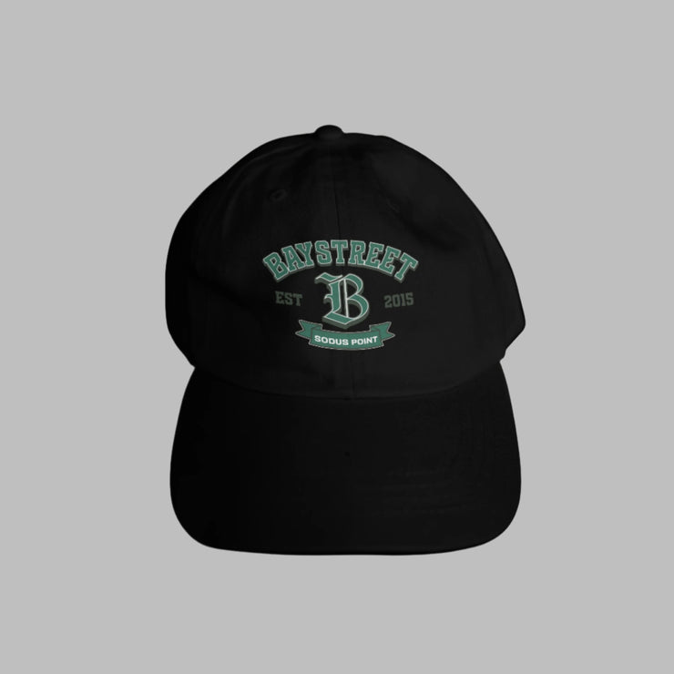 Black cap with green text and logo on a gray surface